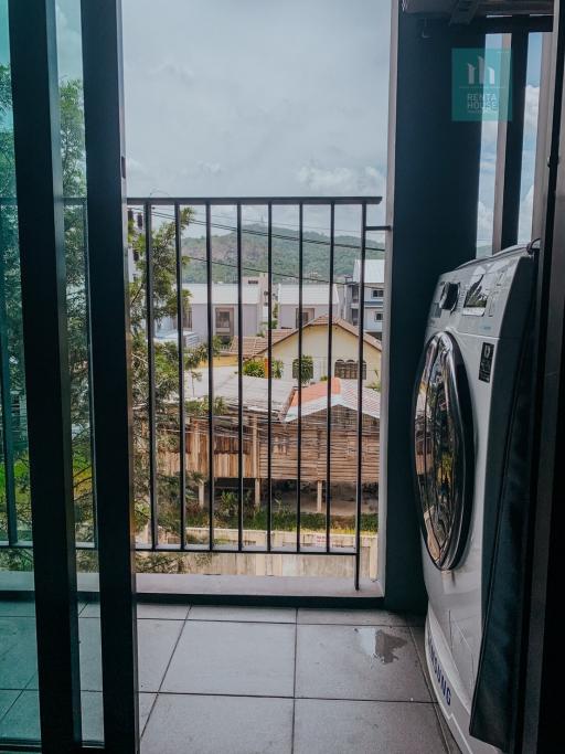 Compact laundry area with a large window overlooking the neighborhood