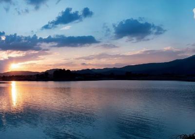 Serene sunset view over a calm lake with mountain backdrop