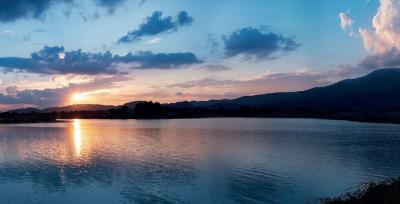 Serene sunset view over a calm lake with mountain backdrop