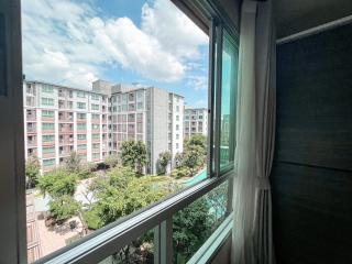 View from a bedroom window showing the neighboring building and greenery