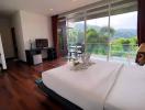 Spacious bedroom with a view of green hills and a balcony