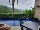Spacious terrace with a pool, dining area, and scenic mountain view