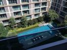 View of residential building with swimming pool and garden from a balcony