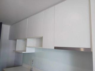 Modern kitchen with white cabinets and stainless steel backsplash