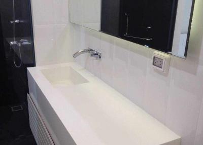 Modern bathroom sink with wall-mounted faucet and mirrored cabinet