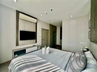 Modern bedroom interior with king-sized bed and wall-mounted television