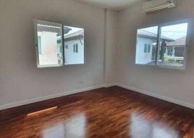 Empty bedroom with wooden floor and natural light