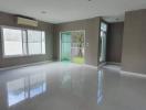 Spacious living room with reflective tile flooring and ample natural light