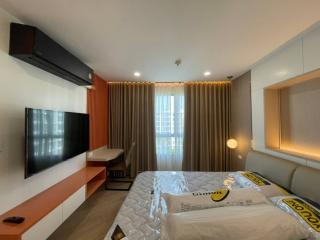 Modern bedroom interior with king-sized bed and large flat-screen TV