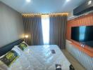 Modern bedroom with large bed and wall-mounted television