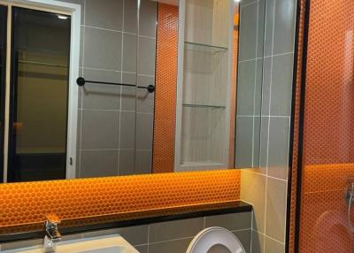 Modern bathroom with orange tiles and glass shower door