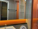 Modern bathroom with orange tiles and glass shower door
