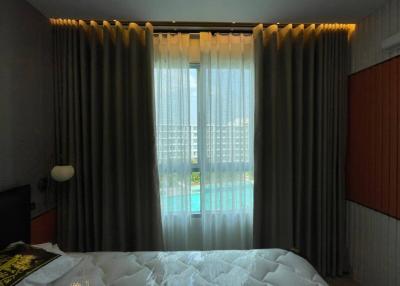 Cozy bedroom with a pool view and large windows