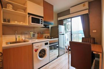 Modern compact kitchen with integrated appliances and dining area