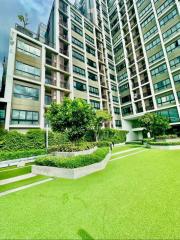 Exterior view of a modern apartment complex with lush green landscaping