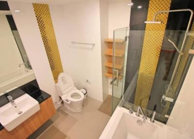 Modern bathroom with a walk-in shower, bathtub, and stylish tiles
