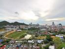 Panoramic view of a vibrant city from a high vantage point with diverse buildings and nature