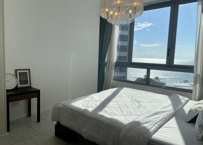 Spacious bedroom with ocean view and elegant chandelier