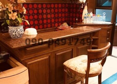 Elegantly furnished wooden kitchen with red backsplash and bar seating