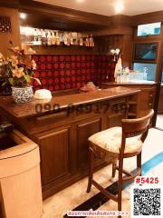 Elegantly furnished wooden kitchen with red backsplash and bar seating