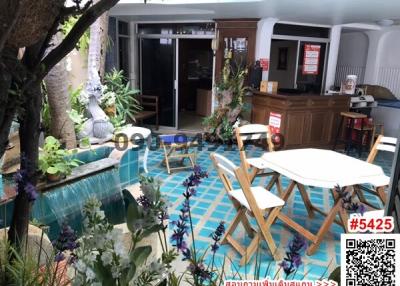 Cozy covered patio with blue tile flooring and lush plant decorations