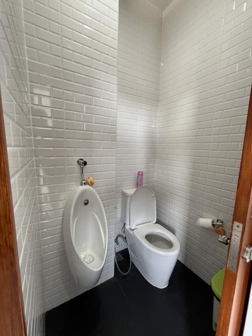 Small bathroom with a white ceramic urinal and toilet