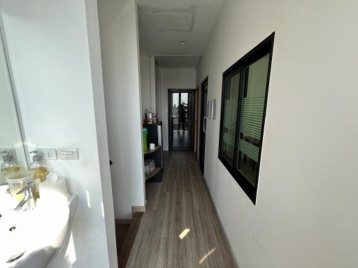 Bright corridor with wooden flooring leading to rooms in a modern home