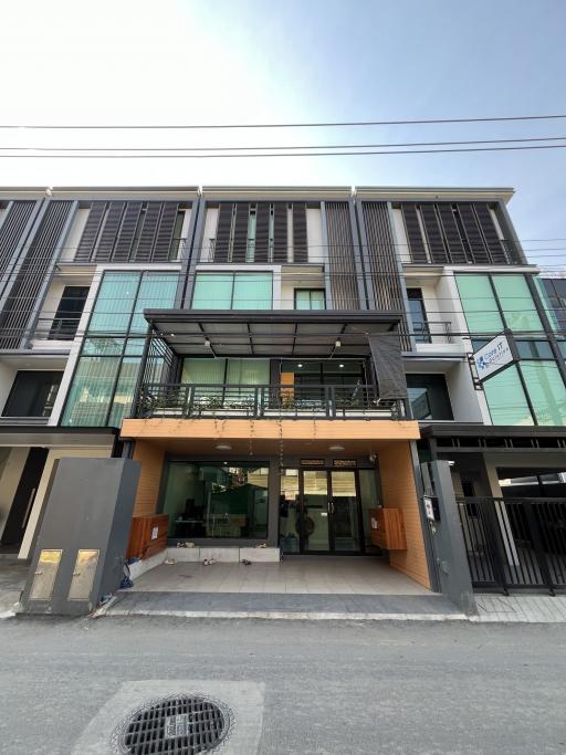 Modern residential building exterior with balconies and commercial space on ground floor