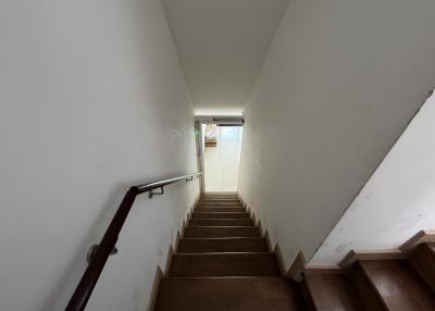 Interior view of a staircase leading upstairs with wooden steps and white walls