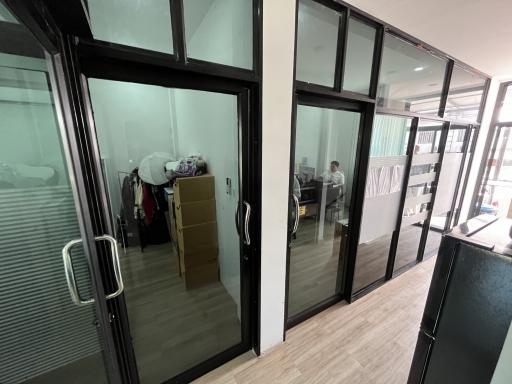 Spacious corridor inside a property with glass doors leading to various rooms