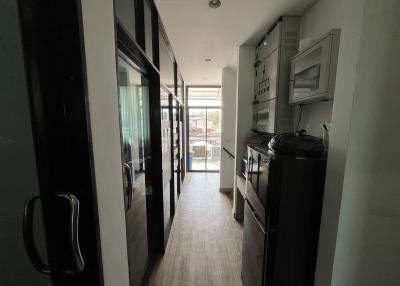 Modern kitchen with wooden flooring, black appliances, and sliding glass door