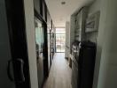 Modern kitchen with wooden flooring, black appliances, and sliding glass door