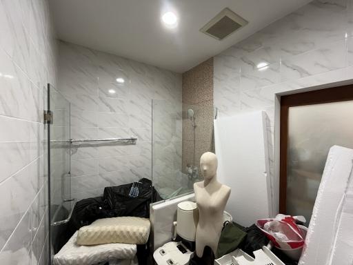 Modern bathroom with white tiling and glass shower partition