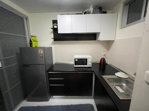 Compact modern kitchen with appliances and gray tiled floor