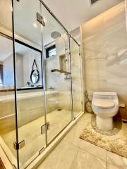 Modern bathroom interior with glass shower and marble tiles