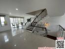 Spacious, modern living area with open floor plan and staircase