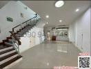 Spacious interior of a residential building with staircase and gleaming tiled floor