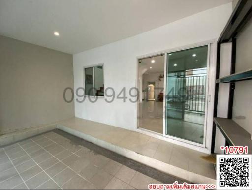 Spacious interior of a building with tile flooring and large glass sliding door leading to a balcony