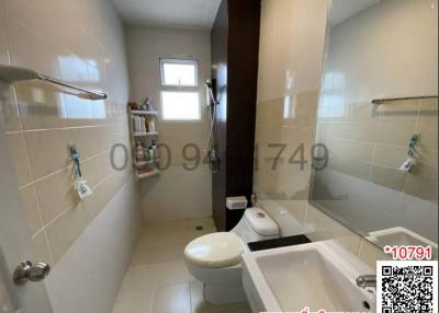 Compact bathroom with toilet, sink and shower area