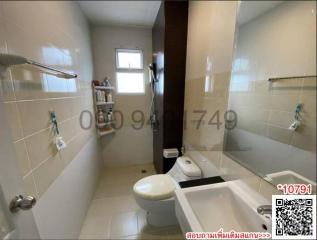Compact bathroom with toilet, sink and shower area