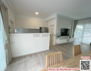 Spacious and well-lit living room with modern open kitchen