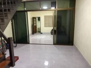 Interior view of a building showing a tiled floor, glass doors, and a staircase