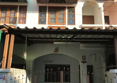 Two-story house facade with gabled roofing and gated entrance