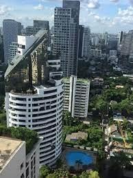 Modern high-rise residential building with surrounding cityscape and pool