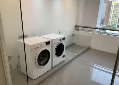 Bright modern laundry room with washer and dryer in a high-rise apartment