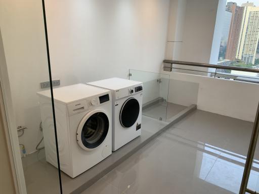 Bright modern laundry room with washer and dryer in a high-rise apartment