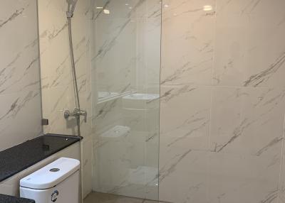 Modern bathroom with marble walls and glass shower partition