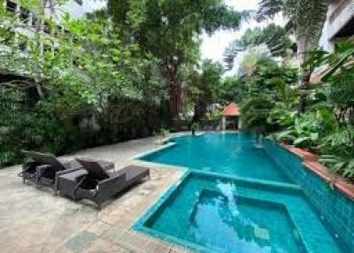 Private swimming pool with loungers surrounded by lush greenery