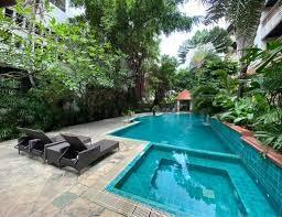 Private swimming pool with loungers surrounded by lush greenery