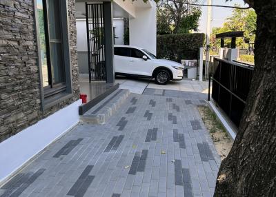 Driveway leading to a modern house with a parked car